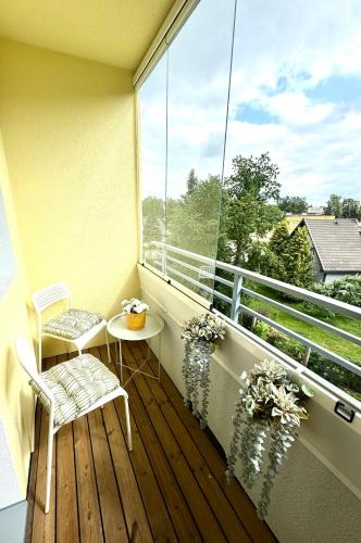 ein Balkon mit Tisch und Stühlen und einem großen Fenster in der Unterkunft Aardla Cozy Apartment in Tartu