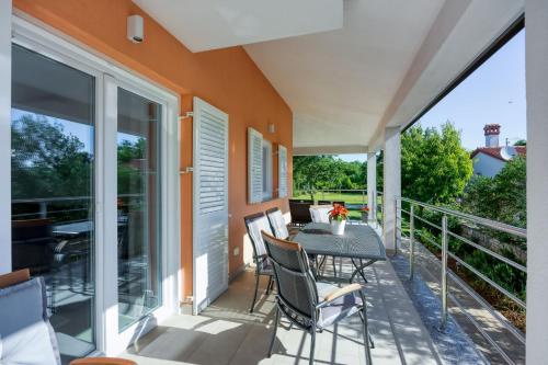 a patio with a table and chairs on a balcony at Holiday House Sunset in Bale