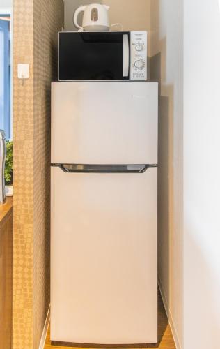 a refrigerator with a microwave on top of it at Life House Tamatsukuri Osaka Castle in Osaka