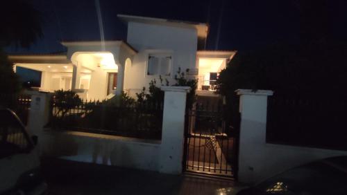 a white house with a gate at night at Avaton Myrina Apartment in Myrina