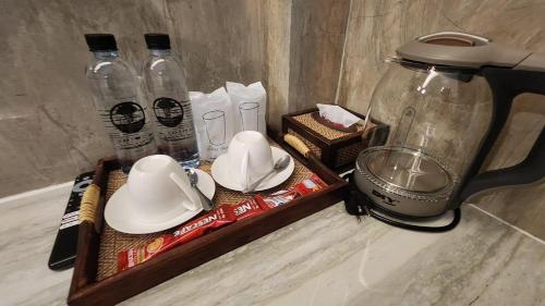 a counter with a blender and bottles of water at บ้านต้นไม้โฮมสเตย์อุทัยธานี in Uthai Thani