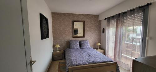 une chambre avec un lit avec des draps bleus et une fenêtre dans l'établissement Spacieux 2 pièces vue mer piscine, à Antibes