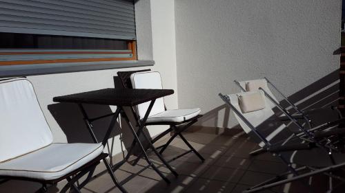 two chairs and a table on a balcony at Alping Apartments in Brunico