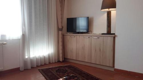 a living room with a flat screen tv on a cabinet at Alping Apartments in Brunico