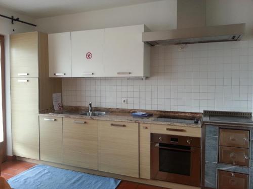 a kitchen with white cabinets and a sink at Alping Apartments in Brunico