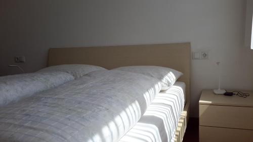 a bedroom with a large bed with white sheets at Alping Apartments in Brunico