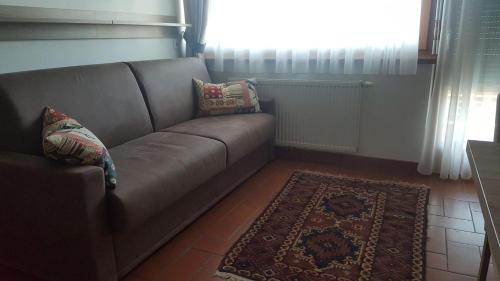 a couch in a living room with a rug at Alping Apartments in Brunico