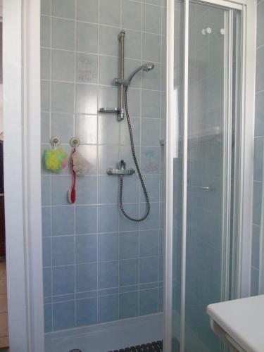 une salle de bain avec douche aux carreaux bleus dans l'établissement Le Lotus, à Saint-Jean-de-Monts