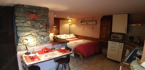 a bedroom with a bed and a stone wall at CleMaison Antica Dimora Apartments CIR VDA GIGNOD 0013 in Gignod