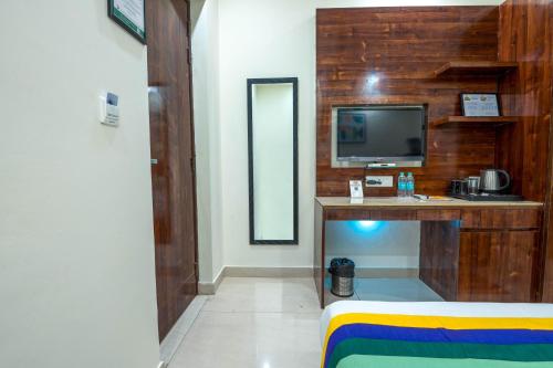 a room with a tv and a desk with a television at Treebo Sunny Feast in Greater Noida