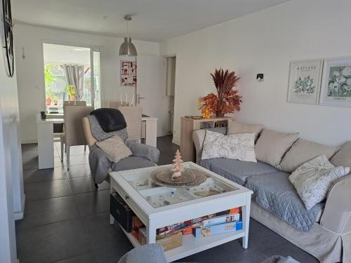 un salon avec un canapé et une table dans l'établissement SPA Familial, Zen Zone Jacuzzi & Jardin, Jeux & Cheminée, à Bourgthéroulde