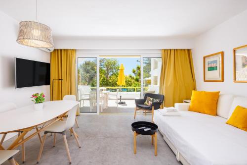a living room with a white couch and a table at Quinta Do Romão in Vilamoura