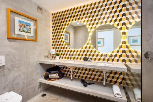 a bathroom with two sinks and two mirrors at Quinta Do Romão in Vilamoura