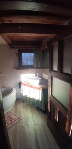 a bathroom with a sink and a tub and a toilet at CleMaison Antica Dimora Apartments CIR VDA GIGNOD 0013 in Gignod