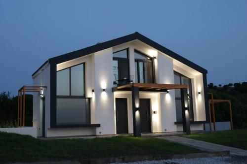 a large white house with a dark roof at Saos Terra Suites in Samothráki