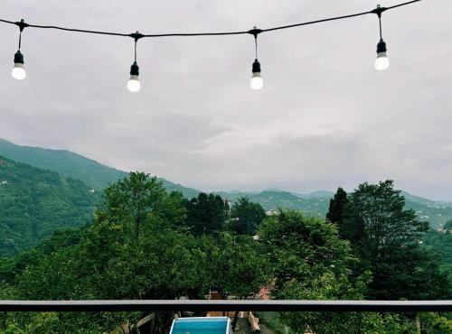 a group of lights hanging from a wire with mountains in the background at Mountain Star in Batumi