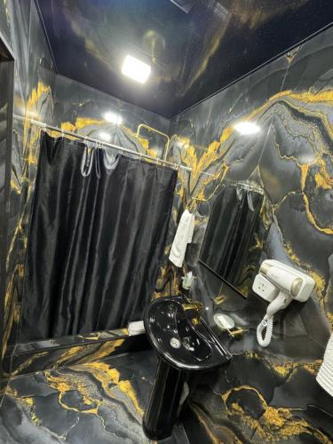 a bathroom with a black and yellow marble wall at Golden Gate Resort in Agveran