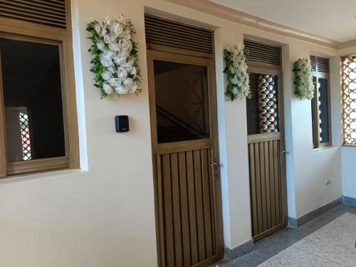 Namuyonba complex في عنتيبي: غرفة بها بابين وزهور على الحائط