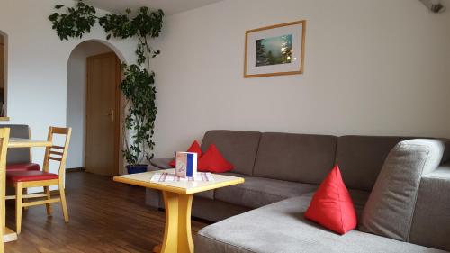 a living room with a couch and a table with red pillows at Pension Truya - Hof in Fiss