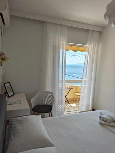 a bedroom with a bed and a view of the ocean at Hotel Rania in Loutra Edipsou