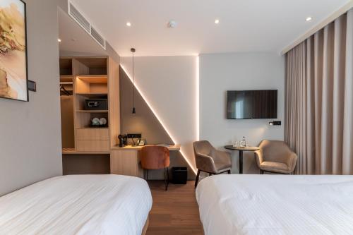 a hotel room with two beds and a table and chairs at The CORNR Hotel in Nieuwpoort