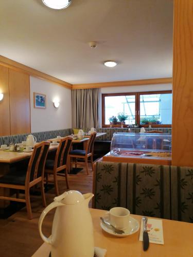 a restaurant with tables and chairs and a tea kettle on a table at Pension Truya - Hof in Fiss