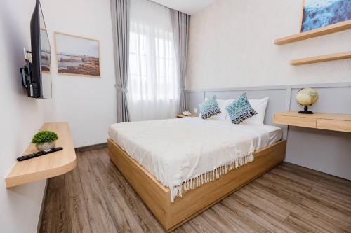 a bedroom with a bed with blue and white pillows at Villa 4BR NovaWorld Phan Thiết for 6-8 pax 09 in Bình Tú