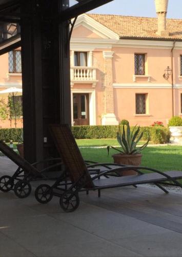 a couple of lawn chairs sitting on a porch at Agriturismo Villa Anconetta in Loreo