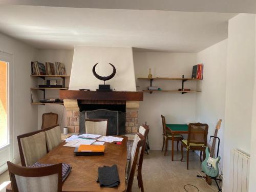 une salle à manger avec une table et une cheminée dans l'établissement villa Esterel calme et proche de la mer,VTT et randonnées, à Saint-Raphaël