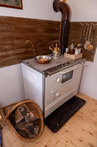 a small stove in a kitchen with a basket at Дановатъ къща in Zgorigrad