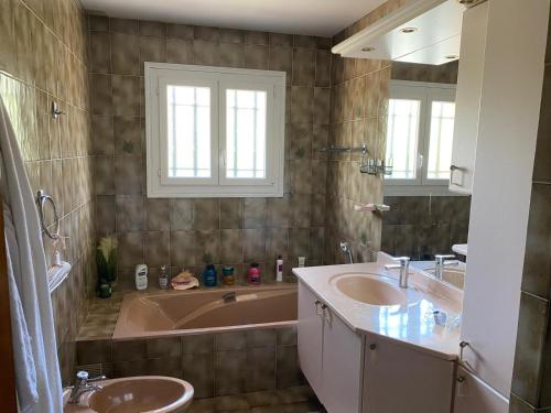 une salle de bain avec deux lavabos et une baignoire dans l'établissement villa Esterel calme et proche de la mer,VTT et randonnées, à Saint-Raphaël