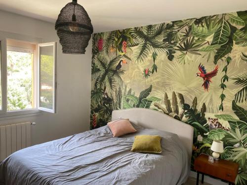 une chambre avec un lit avec un papier peint tropical dans l'établissement villa Esterel calme et proche de la mer,VTT et randonnées, à Saint-Raphaël