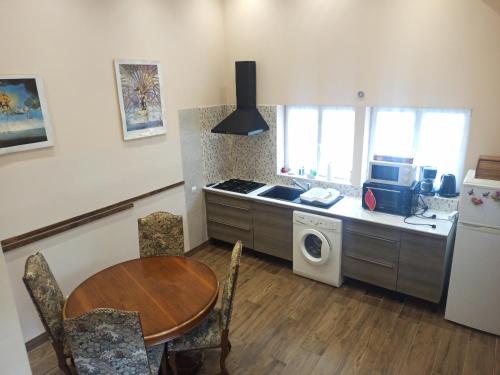 La cuisine est équipée d'une table, d'une cuisinière et d'un réfrigérateur. dans l'établissement Duplex at the foothills of the Pyrenees, à Geu