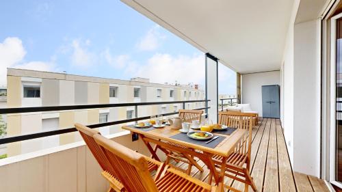 Cet appartement dispose d'un balcon avec une table et des chaises en bois. dans l'établissement expat renting - Le Petit Mosaïque - Patte d'Oie - Wifi, à Toulouse