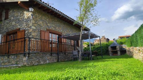 una casa de piedra con una parrilla en un patio en Cal Pujol by Rural House, en Toloríu