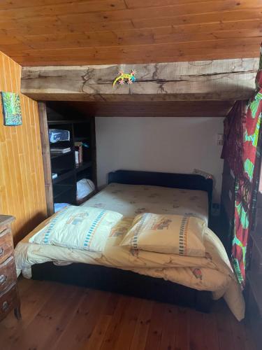un lit dans une chambre avec un plafond en bois dans l'établissement Studio meublé campagne, à Saint-Pey-de-Castets