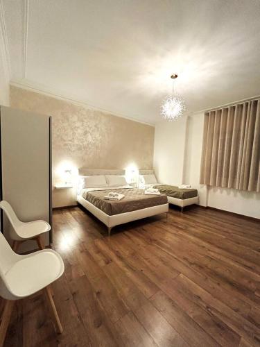 a bedroom with a bed and a couch and a chair at EFFE Home in Catania