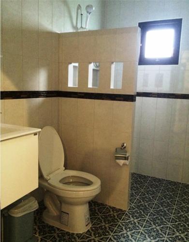 a bathroom with a white toilet and a window at Dachatorn Village in Khao Lak
