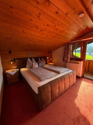 a large bed in a room with a wooden ceiling at Jägerhof in Alpbach
