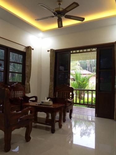 a living room with a table and two chairs at Dachatorn Village in Khao Lak