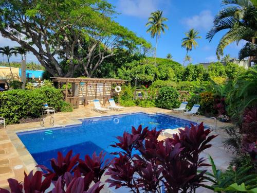 a pool in the backyard of a house with palm trees at Stunning Oceanfront Condo - The Seashore Hideaway, Wailua Bay View, Unit 208, Kapaa in Kapaa