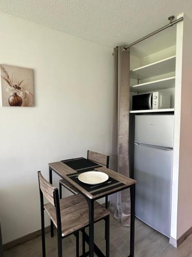 une table à manger avec deux chaises et un réfrigérateur dans l'établissement Charmant Studio Le Bourget-du-Lac, au Bourget-du-Lac