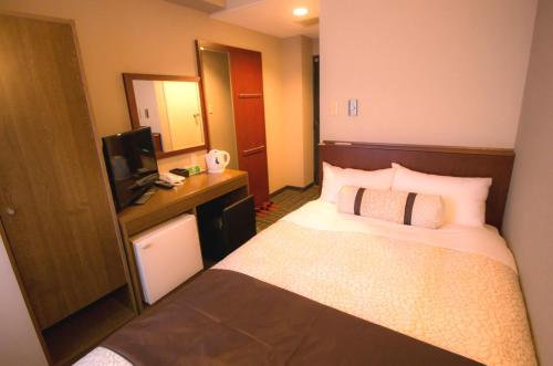 a hotel room with a bed and a television at Kuretake-Inn Tokyo Funabori in Tokyo