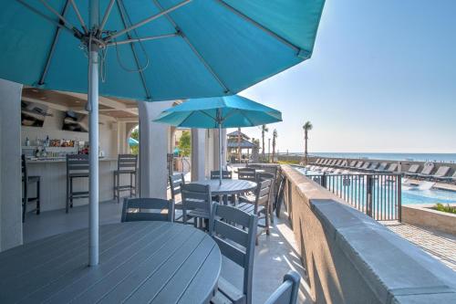 a table with chairs and umbrellas on a balcony with the beach at The Oasis at Orange Beach 2006 (Phoenix West II) in Orange Beach