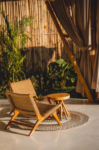 a chair and a table in a room with a plant at Nivriti Bali in Sidemen