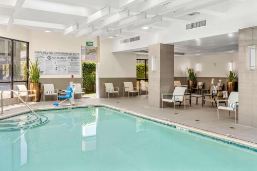 a pool in a hotel lobby with chairs and tables at Embassy Suites by Hilton Irvine Orange County Airport in Irvine