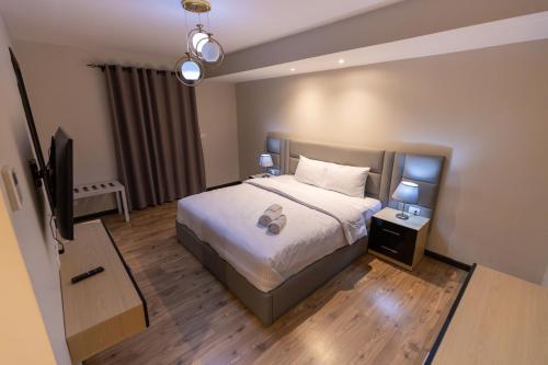 a bedroom with a bed and a flat screen tv at Luxury 3BR Pool View Near Airport! in Cairo