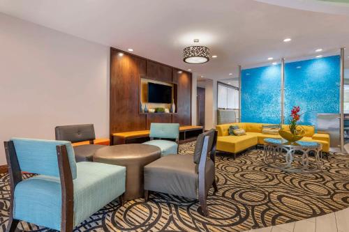 a lobby with a waiting room with a couch and chairs at Comfort Suites Fort Lauderdale Airport South & Cruise Port in Dania Beach