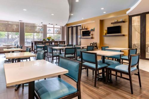 a restaurant with tables and chairs and a television at Comfort Suites Fort Lauderdale Airport South & Cruise Port in Dania Beach
