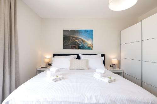 a bedroom with a large white bed with two white towels at CROWONDER Villa Bura with Heated Swimming Pool and Jacuzzi in Privlaka